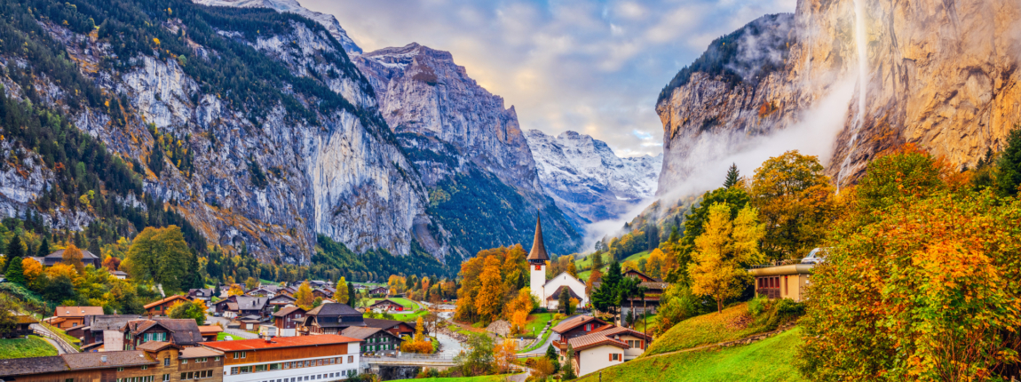 Vibrant autumn scene in a Swiss alpine village nestled in a lush valley surrounded by tall mountains and waterfalls, showcasing scenic landscape, traditional architecture, and colorful fall foliage.