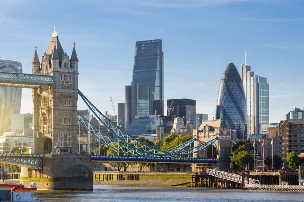 Modern London skyline featuring the Tower Bridge and historic and contemporary skyscrapers including The Gherkin and The Shard. Iconic landmarks combine with the city’s modern architecture along the Thames River.