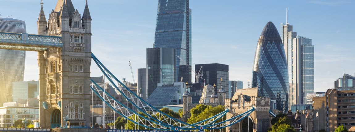 Modern London skyline featuring the Tower Bridge and historic and contemporary skyscrapers including The Gherkin and The Shard. Iconic landmarks combine with the city’s modern architecture along the Thames River.