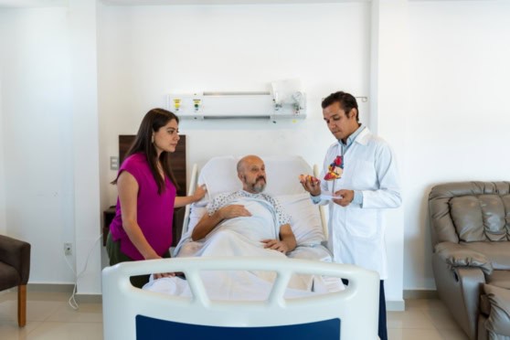 Alt text: Medical professionals consulting with a patient in a hospital room, emphasizing healthcare and patient support.