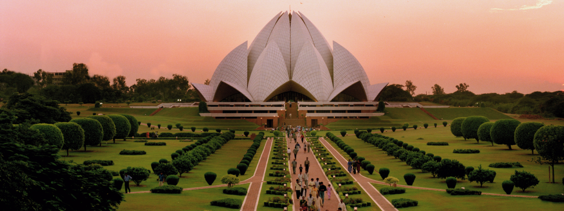 A stunning view of the Lotus Temple with well-maintained gardens, emphasizing global connectivity and the importance of reliable international health insurance coverage.