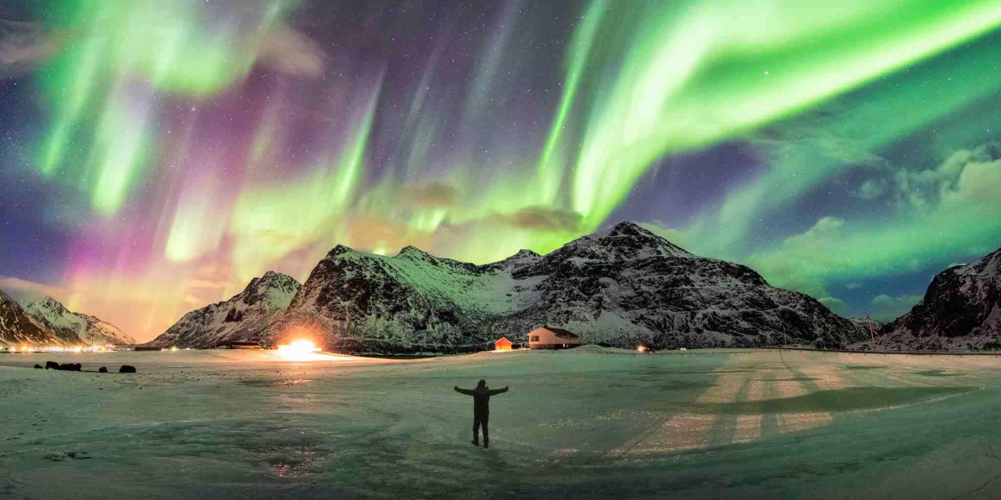 a tourist watching the Northern Lights, indicating one of the major travel trends in 2026
