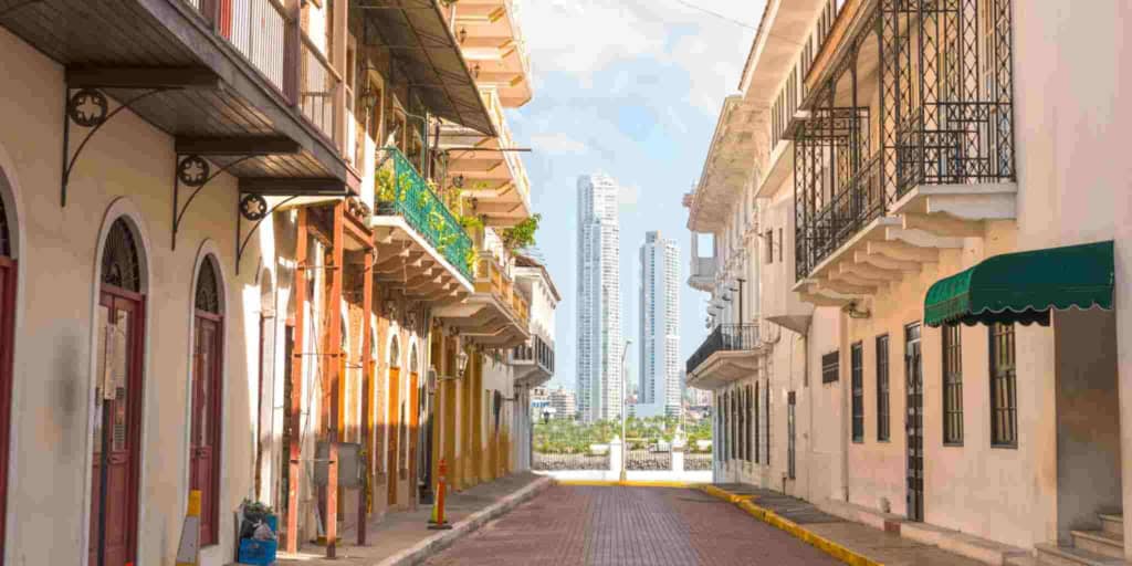 Beautifully styled urban architecture with balconies and vibrant colors on a sunlit street.