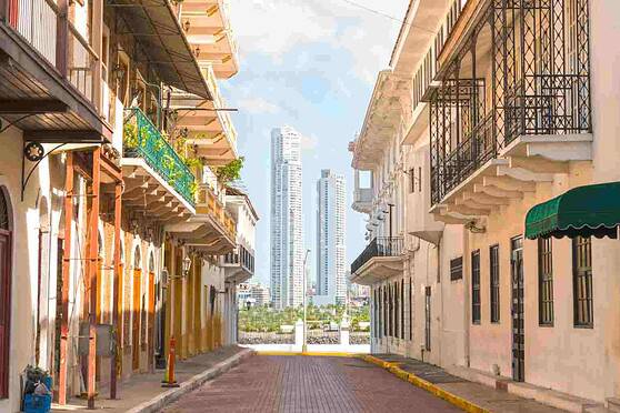 Beautifully styled urban architecture with balconies and vibrant colors on a sunlit street.