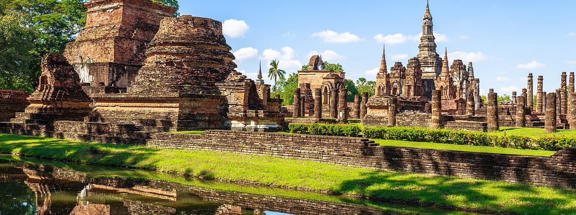 Ancient Thai temples and ruins overlooking a reflective pond, showcasing historical architecture and cultural heritage at ICI 2025.