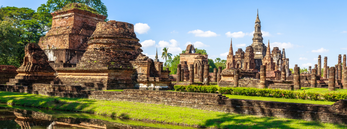 Ancient Thai temples and ruins overlooking a reflective pond, showcasing historical architecture and cultural heritage at ICI 2025.