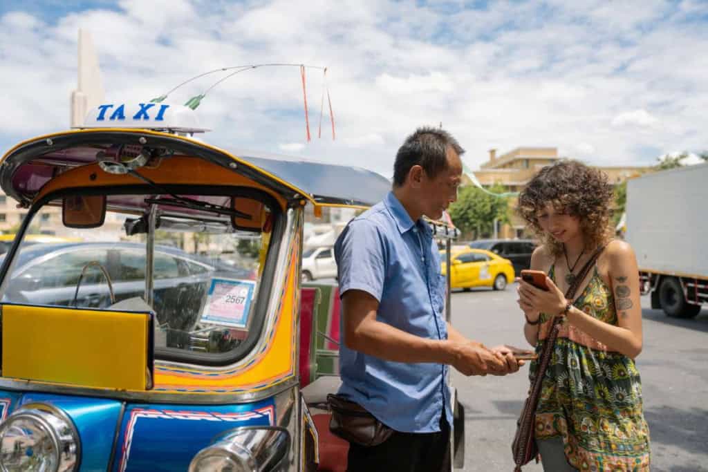 a female traveler trying to avoid one of the common tuk tuk travel scams in Thailand