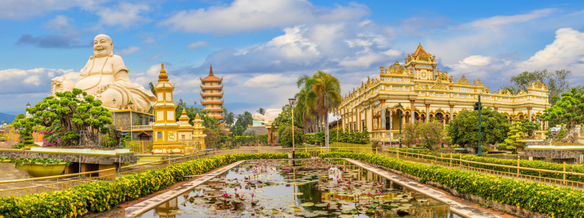 Golden Buddha statue and ornate temple architecture in a lush, landscaped garden with lotus pond, showcasing cultural heritage and serene environment at ICI 2025.