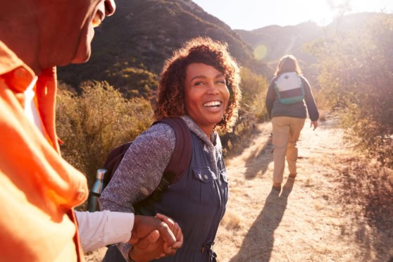 A diverse group of hikers enjoying outdoor adventure, with one woman smiling warmly, symbolizing safety and exploration for global travelers.