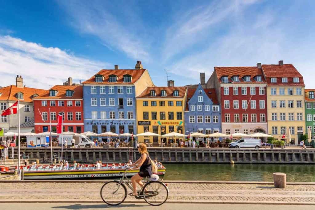 a woman cycling a bike in Copenhagen, one of the best countries to live in as an expat