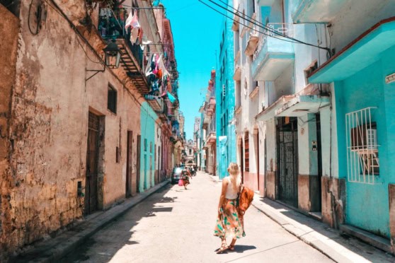 Bright blue sky over aged, charming buildings with hanging laundry and outdoor balconies, capturing a picturesque, multicultural urban area.
