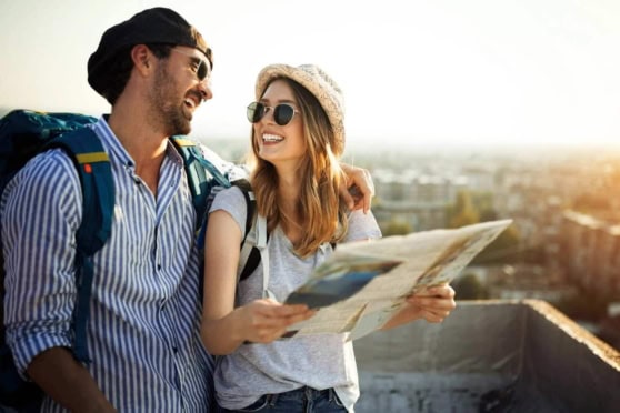 Vibrant image of happy young couple exploring cityscape with a map, representing international travel, adventure, and the need for reliable international insurance coverage.