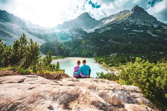 A couple enjoying scenic mountain views and lake scenery, emphasizing outdoor adventure and travel experiences for international citizens exploring nature.