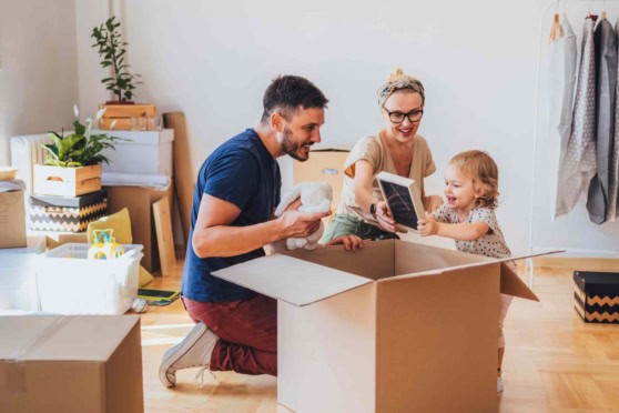 A cheerful U.S. family unpacking their belongings in a new home, emphasizing the importance of international health coverage when moving abroad from America