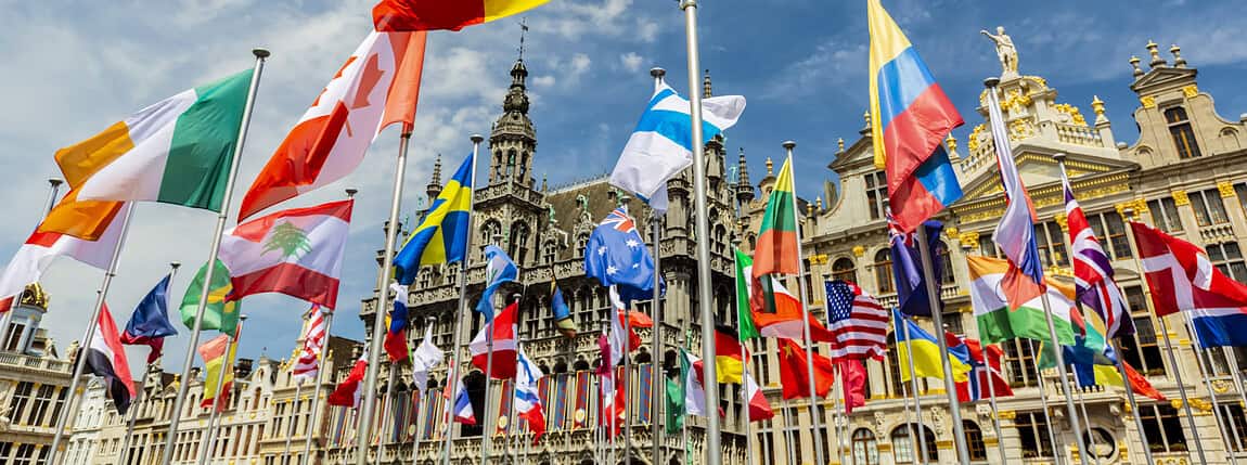 Flags representing multiple countries in a vibrant plaza setting, emphasizing the importance of worldwide coverage and global protection plans.