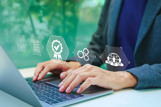 Image shows business professional using a laptop with digital icons representing insurance, certification, and global connectivity.