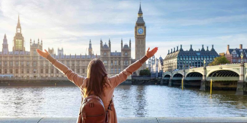 a female tourist standing in front of the Houses of Parliament in London, UK, one of the visa-free countries for US citizens
