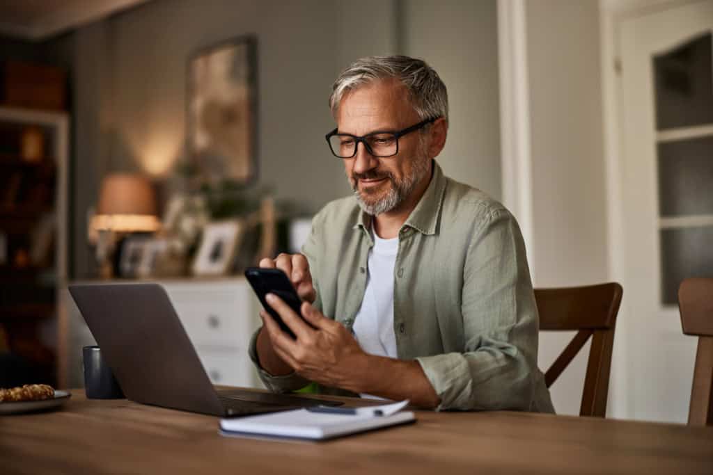 A man applying for insurance on a laptop while speaking to an advisor