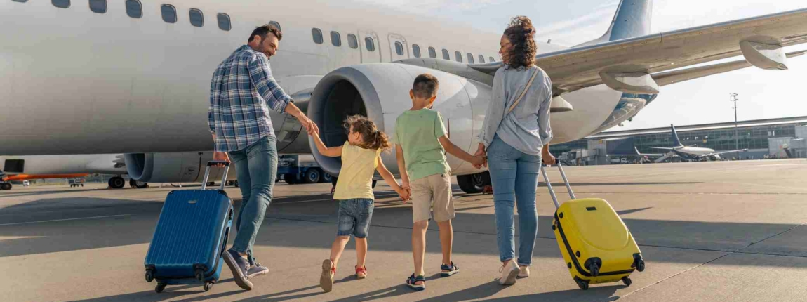 Family with children arriving at plane with rolling suitcases, ready for international travel from airport terminal, enjoying vacation.