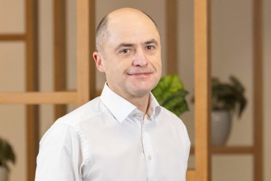 An image of a confident man dressed in a white shirt, representing trusted international insurance solutions, with a professional background highlighting reliability.
