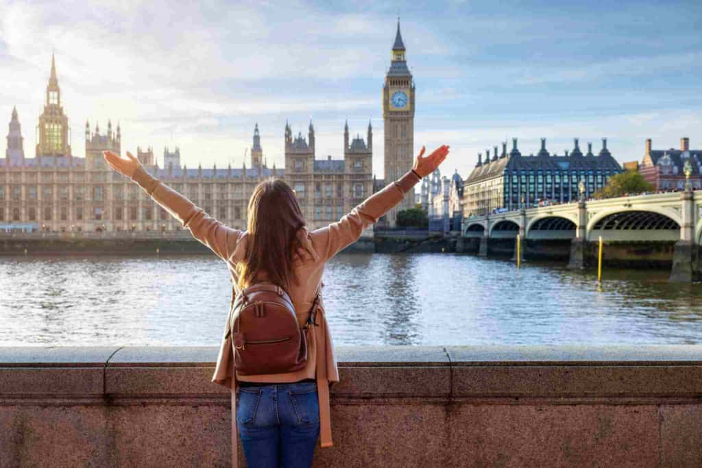 a female tourist standing in front of the Houses of Parliament in London, UK, one of the visa-free countries for US citizens