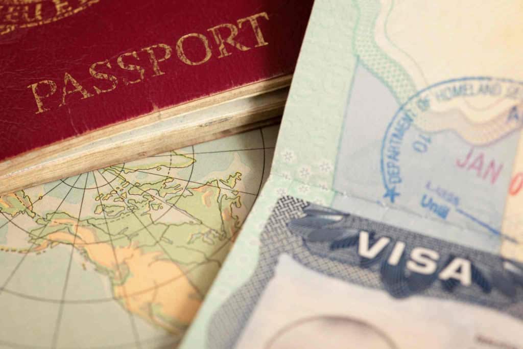 A close-up of a passport, visa document, and world map, symbolizing international travel and global insurance protection for citizens traveling abroad, ensuring peace of mind and coverage across borders.