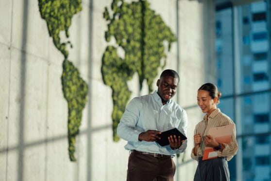 Diverse professionals discussing insurance plans inside an office with a world map wall decor.
