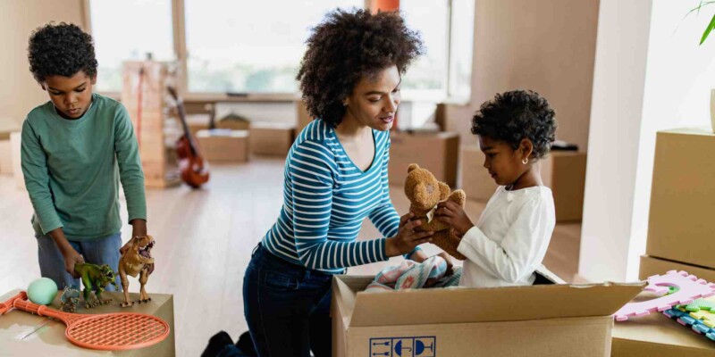 a mother and her children packing boxes getting ready to move abroad 