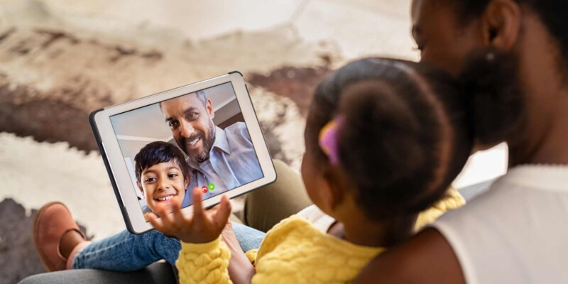 a family having a video chat with friends on a tablet