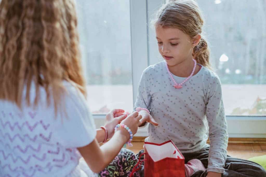 a little girl gifting a friendship bracelets and saying goodbye before moving abroad