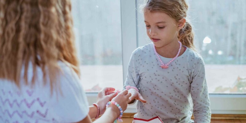 a little girl gifting a friendship bracelets and saying goodbye before moving abroad