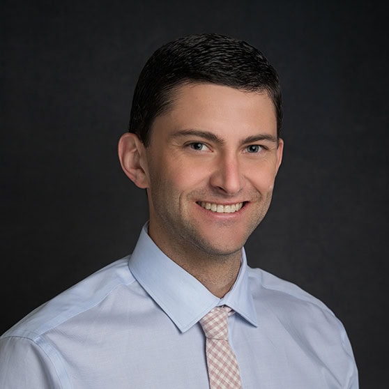 A professional smiling man in business attire promotes international health insurance and global coverage solutions.