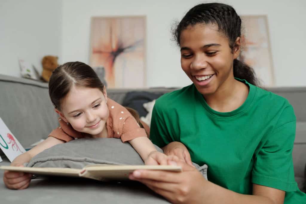au pair reading with young child at home