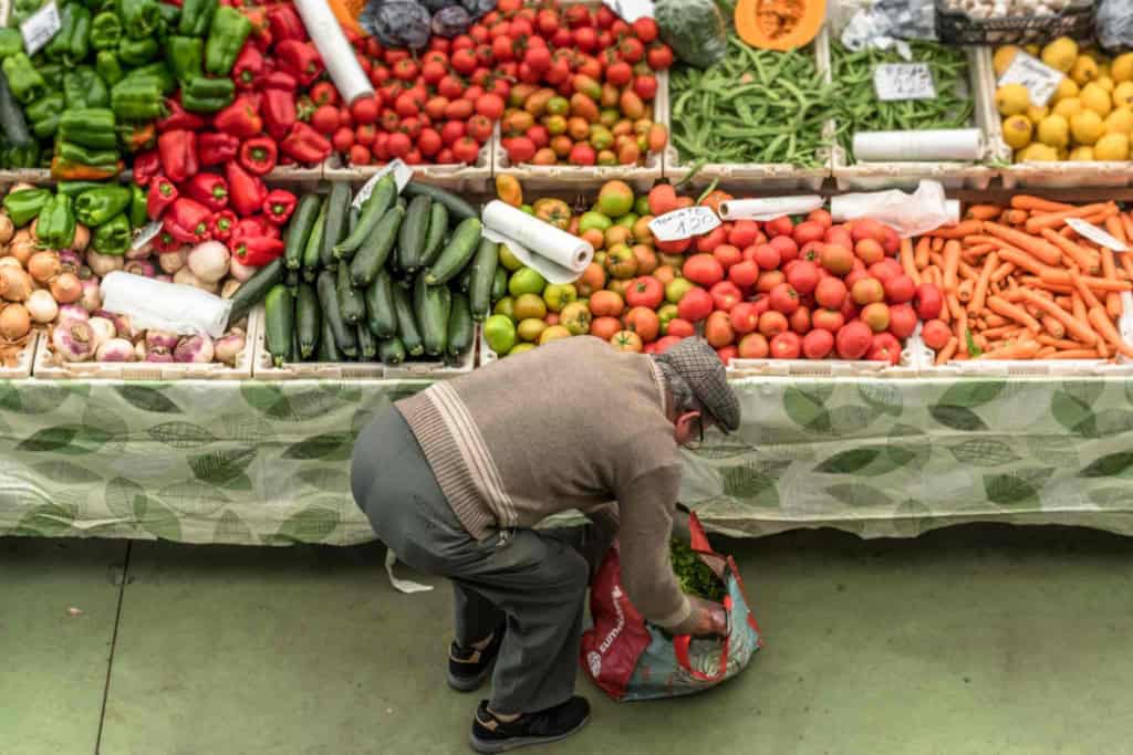 a senior man shopping at a fruit and vegetable market