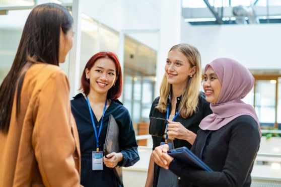 Diverse women having a friendly discussion at an international conference.