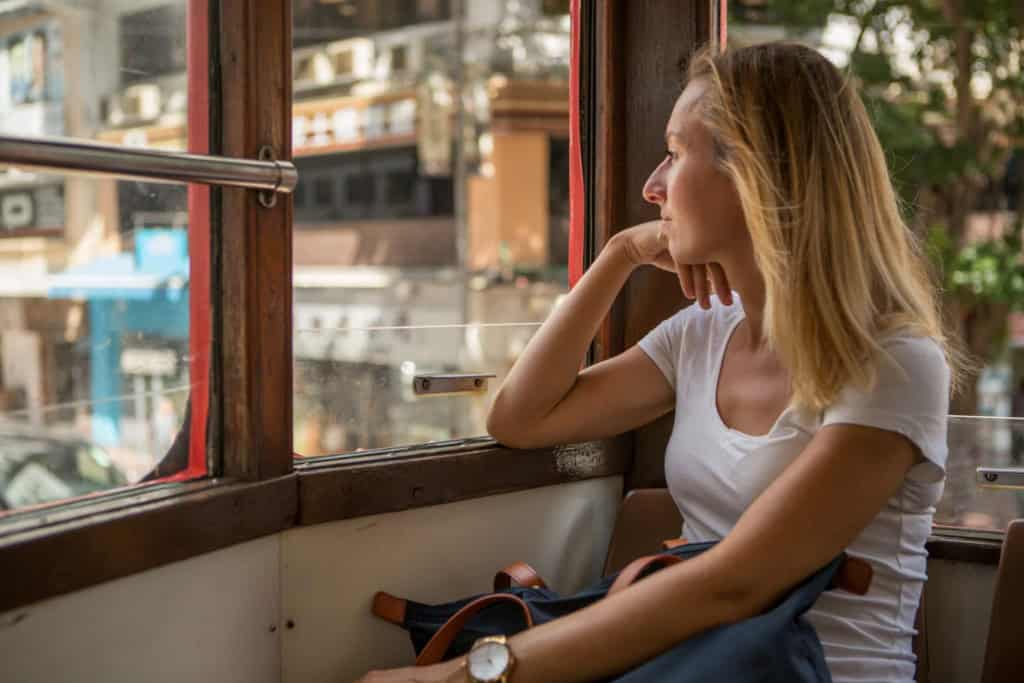an expat riding the tram in Hong Kong, where health insurance is recommended for better quality care.