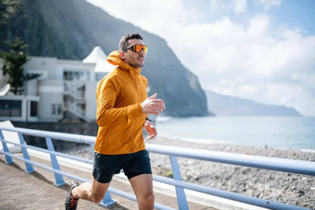 a man jogging in the sun, wearing UV protection sunglasses, one of the best skin care tips for expats