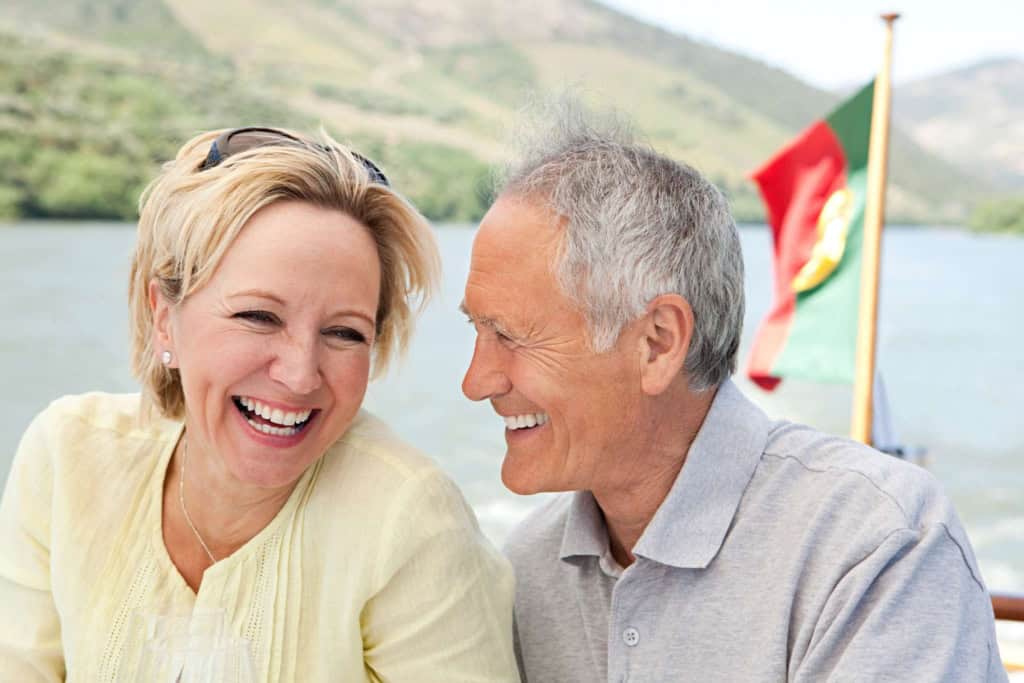 a happy senior couple on a boat, illustrating the joy of retiring in Portugal