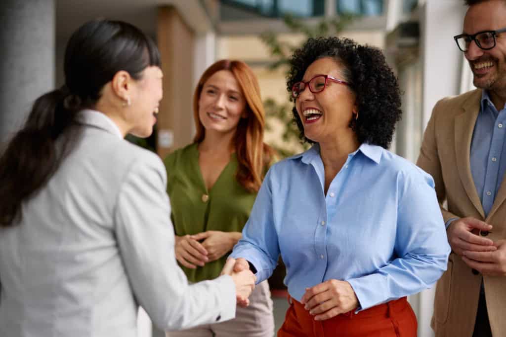 business people shaking hands and networking prior to going on global assignments as a way of reducing employee culture shock abroad