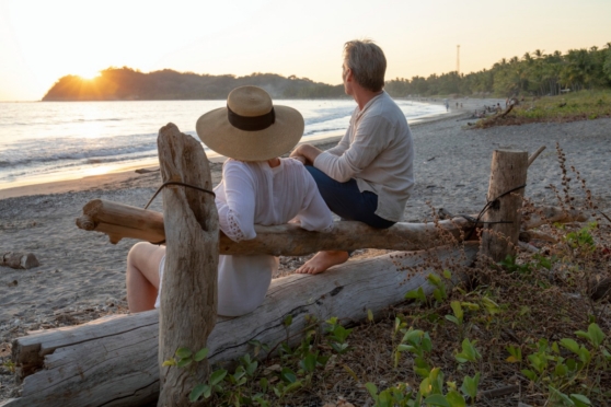 a happy retired couple relaxing on a beach, after moving to Costa Rica