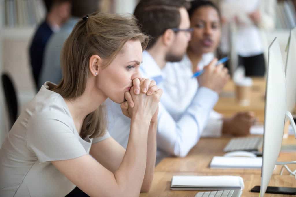 a female worker sitting at a laptop showing signs of employee culture shock