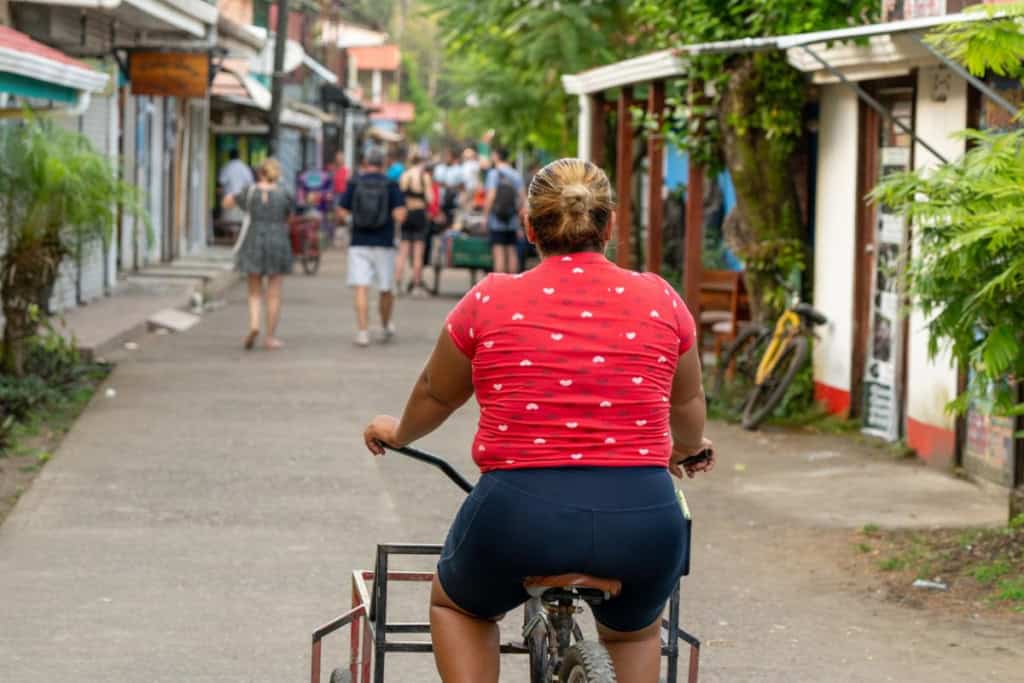 a woman riding a bicycle in Tortuguero town, Costa Rica