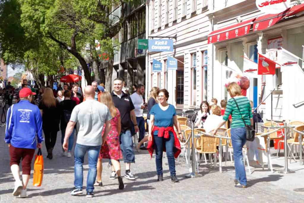 People walking and socializing on a lively Swedish street in Östersund, one of the most popular destinations for retiring in Sweden