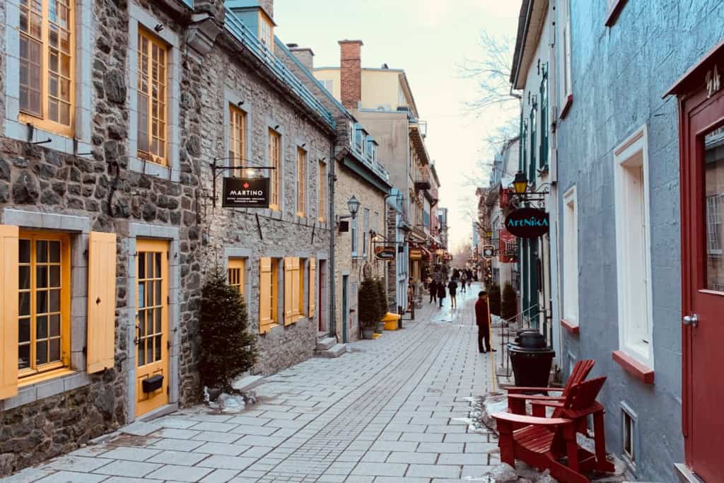 An inviting street scene in a picturesque Canadian town, showcasing historic stone buildings, cozy storefronts, and a peaceful atmosphere ideal for retirees seeking a scenic and relaxed lifestyle.