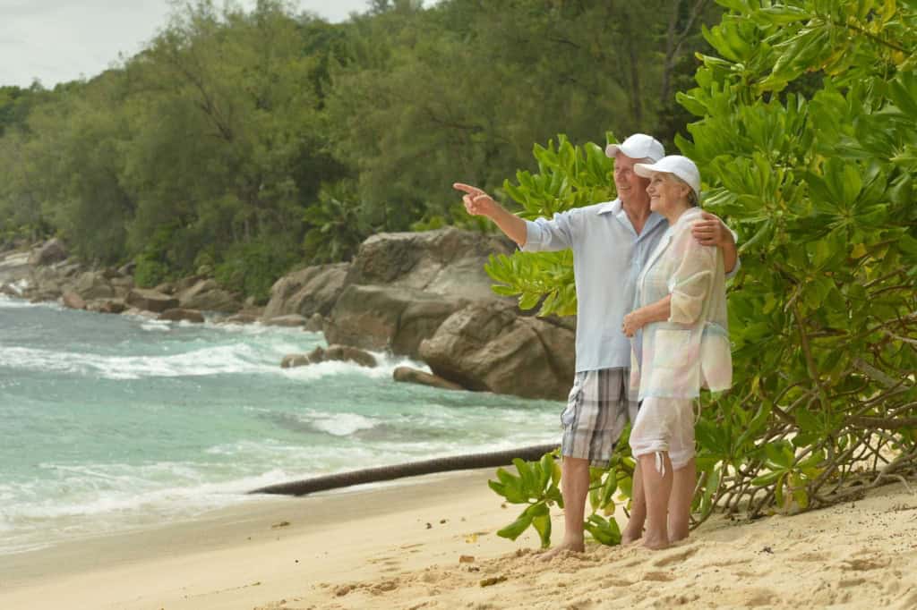 Elderly couple walking along the seashore in Phuket, one of the best places to retire in Thailand
