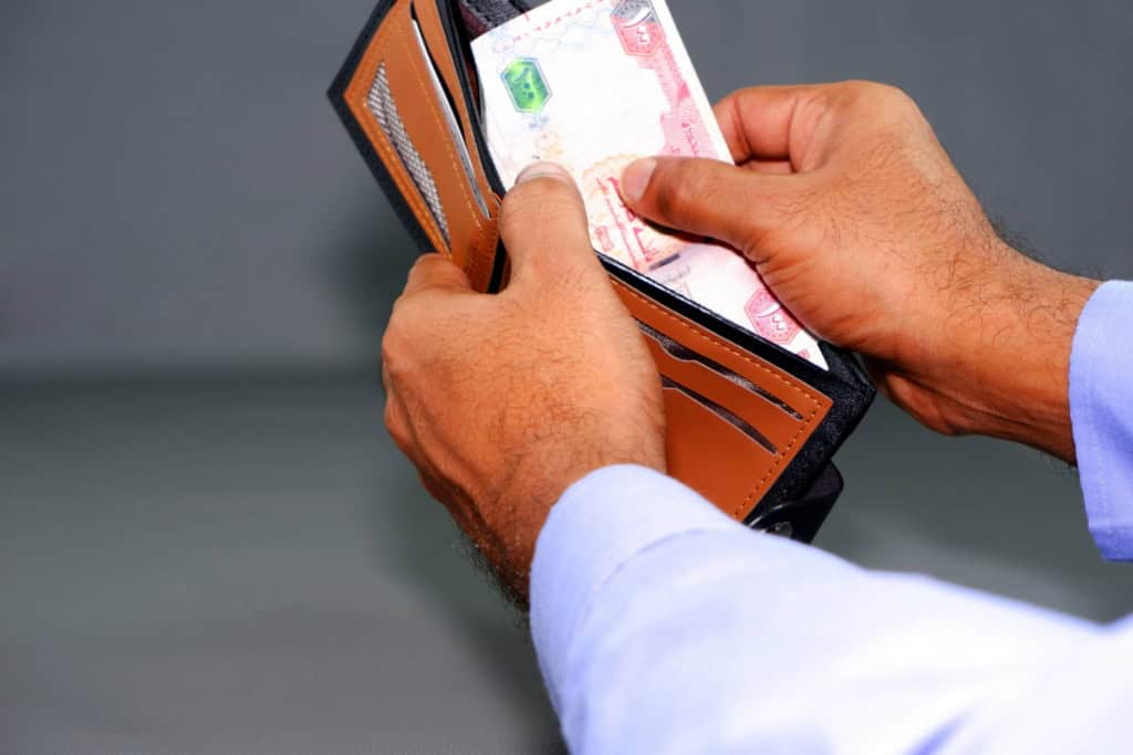a wallet with Dirham notes in UAE, one of the most popular expat countries with no income tax