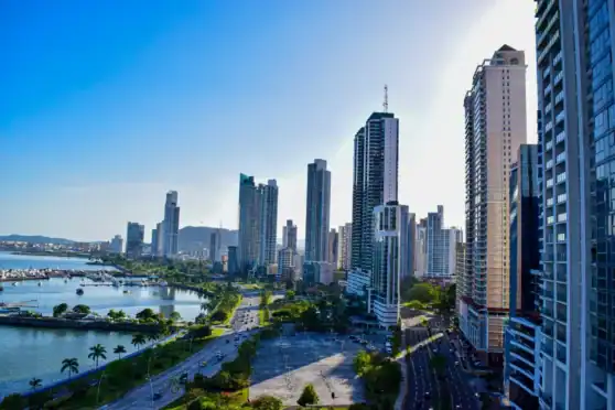 A panoramic view of Panama City featuring tall skyscrapers, a river, and lush green areas, highlighting the vibrant urban landscape ideal for international residents moving to Panama.
