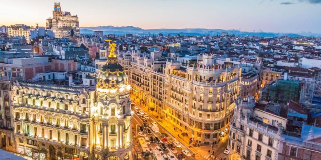 A panoramic view of a historic European cityscape at dusk, showcasing iconic architecture and vibrant city life, highlighting the importance of international health insurance for expatriates.