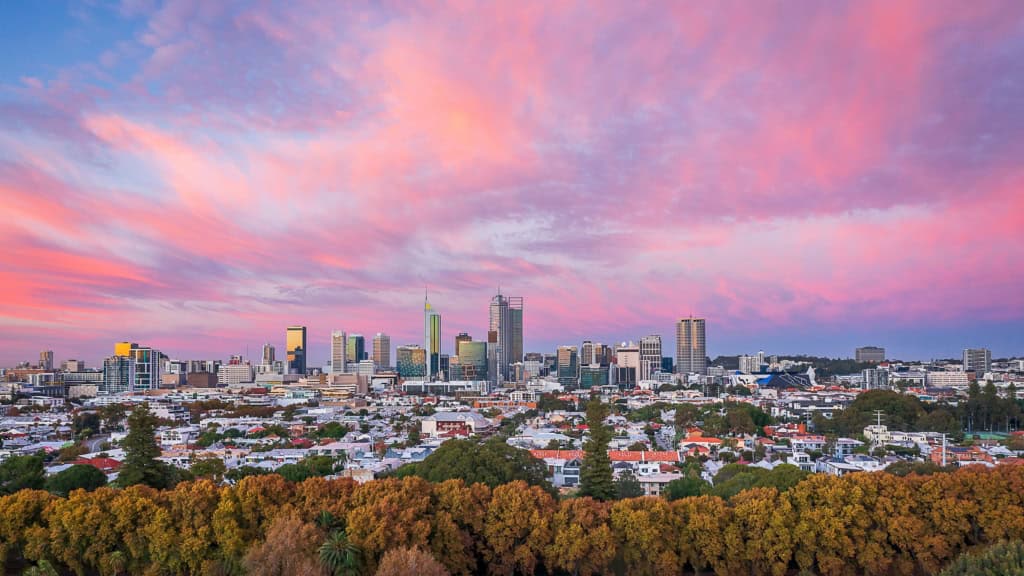 An expansive view of Australia's city skyline during sunset, highlighting modern skyscrapers and vibrant city life.