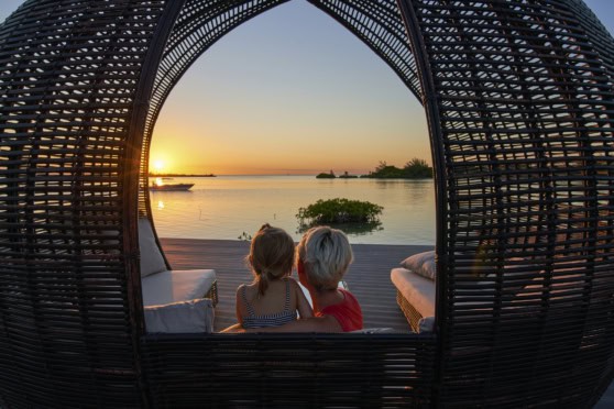 Beautiful sunset over the Belize coast seen through a cozy, woven cabana.